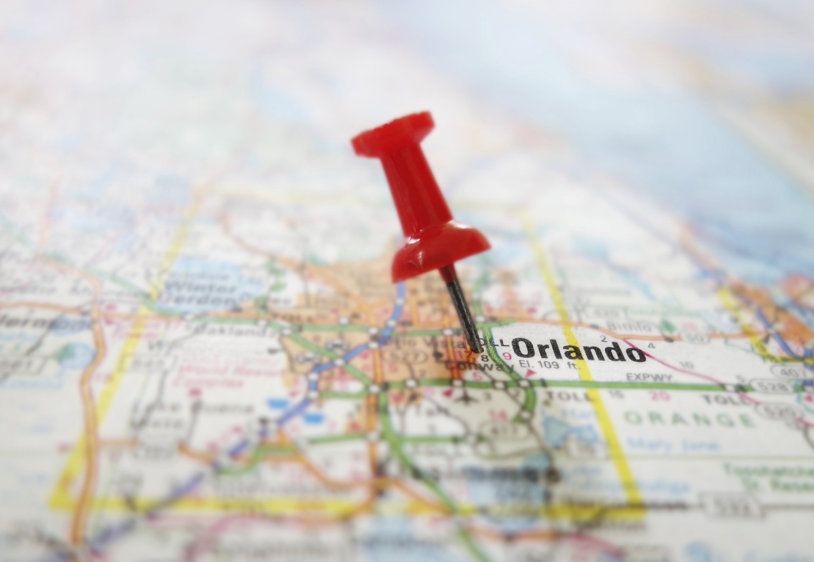 Closeup of a red tack in a map of Orlando Florida